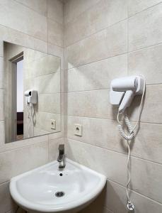 a bathroom with a white sink and a mirror at PushApart Lviv in Lviv