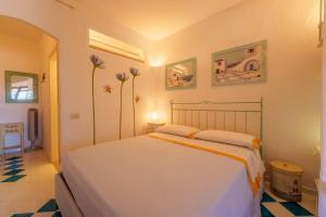 a bedroom with a white bed and flowers on the wall at Residence La Virginia in Palau