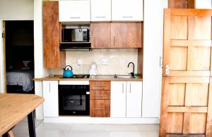 a kitchen with white cabinets and a sink at Sunnyside Haven in Grahamstown