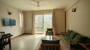 a living room with a couch and a large window at Serai Habitat in Solan