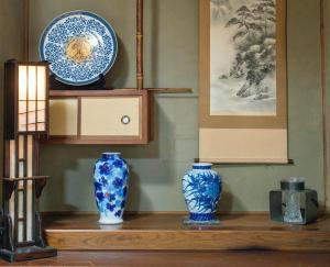 three blue vases sitting on a wooden shelf at Guesthouse Matsuo A in Fukuoka
