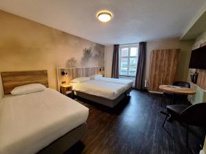 トールンにあるFletcher Hotel La Ville Blancheのベッドが2つと窓があるホテルの部屋