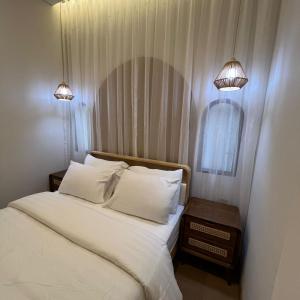 a bed with two white pillows and two lamps at Casabella 106 BCS A2 Grand Batam Penuin Wet Market in Nagoya