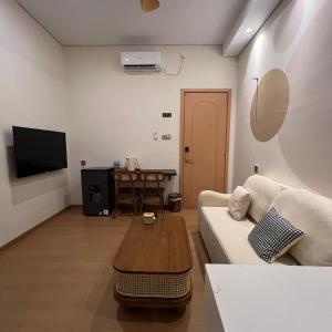 a living room with a white couch and a table at Casabella 106 BCS A2 Grand Batam Penuin Wet Market in Nagoya