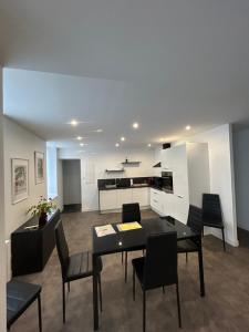a living room with a table and chairs and a kitchen at Appartement 4 personnes joliment rénové proche du Centre-ville in Épinal