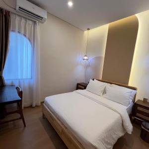 a bedroom with a white bed and a window at Casabella Homestay 207 Batam Penuin in Nagoya