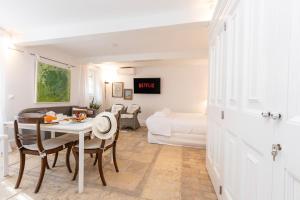 a living room with a table and a bedroom at Ventoura Suites, Corfu Old Town in Corfu
