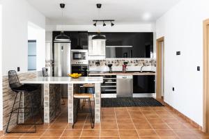 Una cocina con electrodomésticos en blanco y negro y una mesa. en Villa Oasys, en Almería