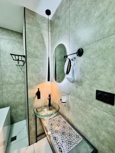a bathroom with a glass sink and a mirror at Квартира у Моря in Batumi