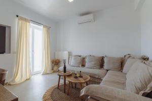 a white living room with a couch and a table at Art of Filoxenia with swimming pool in Andiparos