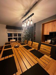 a dining room with a wooden table and chairs at KOLO Котеджний комплекс in Tatariv