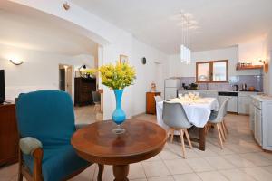 Una cocina y un comedor con un jarrón de flores sobre una mesa. en L’Écrin du Brulat - Jardin et vue montagnes, en Le Castellet