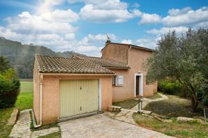 Una pequeña casa de ladrillo con garaje. en L’Écrin du Brulat - Jardin et vue montagnes, en Le Castellet
