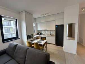 a living room with a couch and a table and a kitchen at Citadel 2 - Powered By NEO - Free Parking in Timişoara