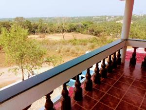 a balcony with a view of a field at The Whitehouse Homestay in Manipal