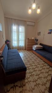 a bedroom with two beds and a couch and a window at Entire Traditional Apartment at the Sea in Nea Plagia