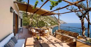 un balcone con tavolo e sedie e l'oceano di Villa Torre Sponda Private Beach a Positano