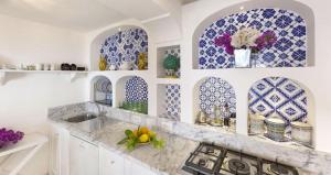 una cucina con piastrelle blu e bianche sul muro di Villa Torre Sponda Private Beach a Positano Altre 42 foto
