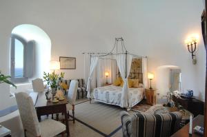 una camera da letto con letto a baldacchino e un soggiorno di Villa Torre Sponda Private Beach a Positano