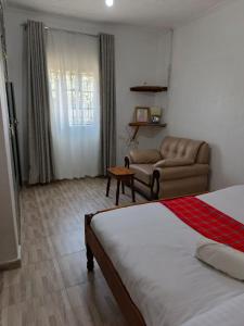 un soggiorno con letto e divano di RUWAMU Guesthouse a Naivasha Altre 11 foto
