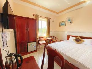 Un dormitorio con una cama y un televisor. en Trung Hậu Hotel, en Con Dao