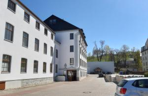a white building with a car parked next to it at Thalheimer Zimmer in Thalheim