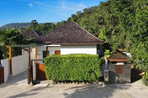 una casa con un seto delante de ella en Thai Balinese Villa Rico in Kamala 3BR, Private Pool, en Kamala Beach