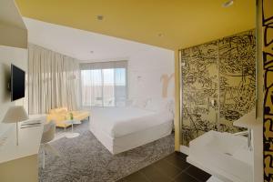 a bedroom with a bed and a living room at nhow Marseille in Marseille