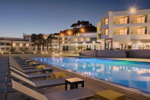 a swimming pool with lounge chairs in front of a building at nhow Marseille in Marseille