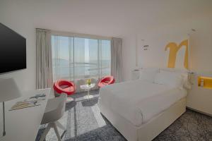 a hotel room with a bed and a desk and a television at nhow Marseille in Marseille