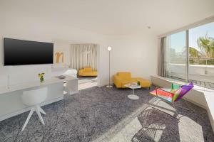 a white room with a desk and a tv at nhow Marseille in Marseille