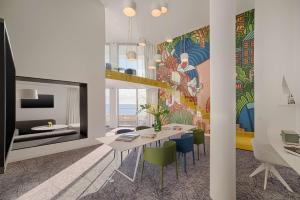 a dining room with a table and chairs with a mural at nhow Marseille in Marseille