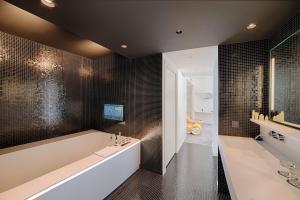 a bathroom with a large tub and a sink at nhow Marseille in Marseille