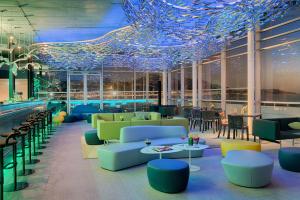 a restaurant with blue ceilings and tables and chairs at nhow Marseille in Marseille