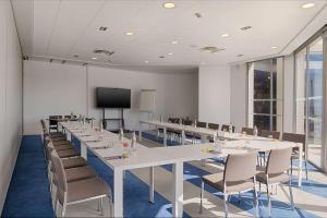 a conference room with tables and chairs and a flat screen tv at nhow Marseille in Marseille