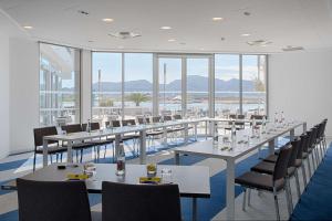 a row of tables and chairs in a room with windows at nhow Marseille in Marseille