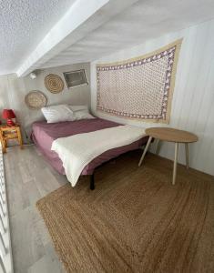 a small bedroom with a bed and a table at Maison de vacance bord de mer in Le Barcarès