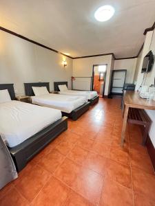 a room with two beds and a desk in it at Nice view guesthouse in Vang Vieng