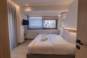 a bedroom with a large white bed with a window at Aeson Premium Living in Volos