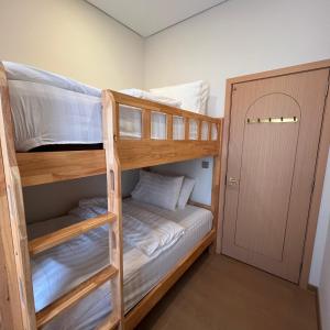 a bunk bed room with two bunk beds and a door at Casabella Homestay 306 Batam Penuin in Nagoya