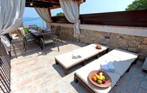 a patio with two couches and a table with fruit on it at Beautiful Stone House Obrs with indoor pool in Kraj