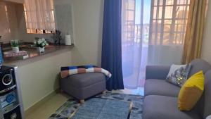 a living room with a couch and a chair at Ponton Stays in Eldoret