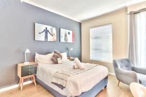 a bedroom with a bed and a chair at WINK Aparthotel Quiver Tree in Stellenbosch