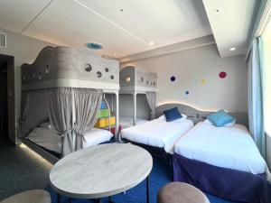 a room with two beds and a table in it at Hotel Keihan Universal Tower in Osaka