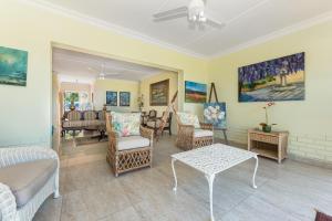 Una sala de estar con sillas, un sofá y una mesa. en 48 Mahogony Drive, Beverly Hills Estate, en Ballito