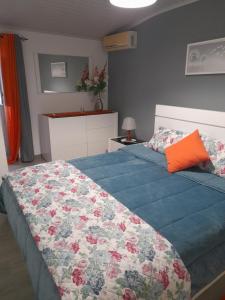 a bedroom with a bed with a blue comforter at O Cantinho da Auzenda in Torre de Moncorvo