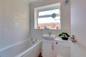 a bathroom with a tub sink and a window at Charming Semi-attached bungalow with free parking Pass the Keys in Cambridge +40 photos