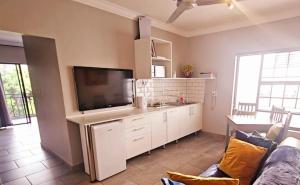 a living room with a couch and a flat screen tv at Highveld Guesthouse in Centurion