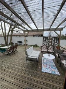 a patio with chairs and a table and a roof at Charming house with garden terrace and barbecue in Saint-Cricq