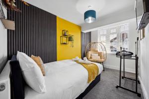 a bedroom with a white bed and a yellow wall at 7 Bedroom Luxury House sleep 26 in Birmingham